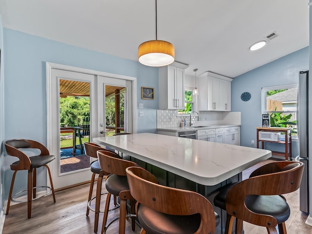 9 Pirates Cove Ln, Saint Marks, FL 32355 - kitchen featuring healthy amount of natural light, backsplash, light wood finished floors, and lofted ceiling