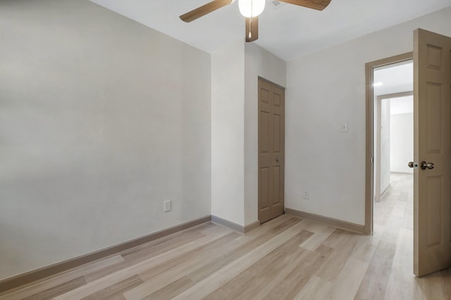 unfurnished room featuring ceiling fan, light wood-type flooring, and baseboards