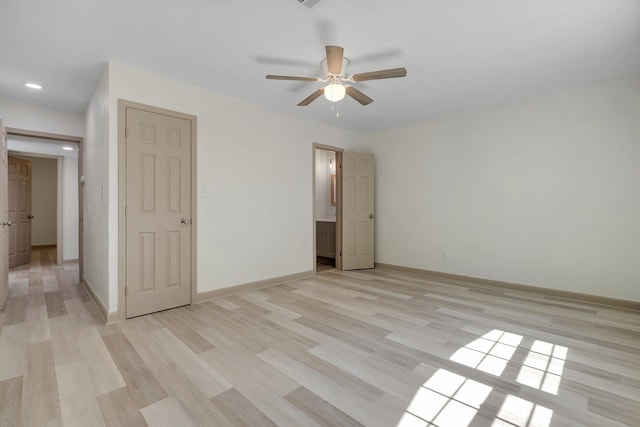 unfurnished bedroom featuring ceiling fan, baseboards, connected bathroom, and light wood-style floors