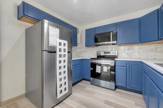 kitchen featuring blue cabinetry, tasteful backsplash, and appliances with stainless steel finishes