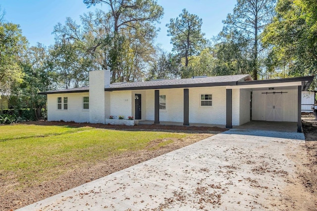 ranch-style home with brick siding, an attached carport, a front lawn, concrete driveway, and a chimney