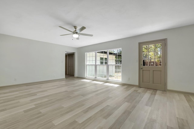 spare room featuring baseboards, light wood-style flooring, and a ceiling fan