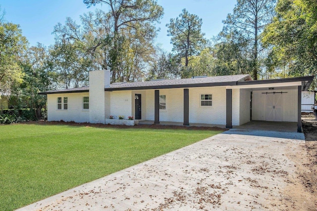 single story home with driveway, a carport, a front yard, brick siding, and a chimney