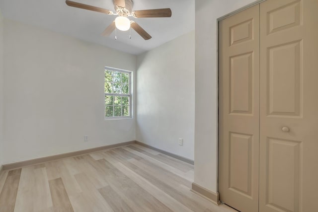 unfurnished room featuring a ceiling fan, light wood-type flooring, and baseboards