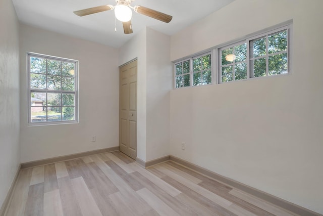 unfurnished bedroom featuring ceiling fan, light wood-type flooring, and baseboards