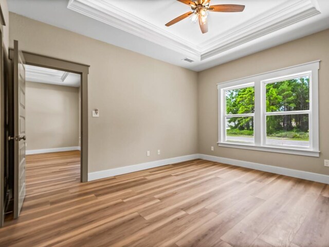 1673 Landing St, Carrabelle, FL 32322 - empty room with a raised ceiling, crown molding, light wood-type flooring, ceiling fan, and baseboards