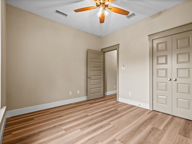 1673 Landing St, Carrabelle, FL 32322 - unfurnished bedroom featuring a closet, light wood-type flooring, baseboards, and ceiling fan