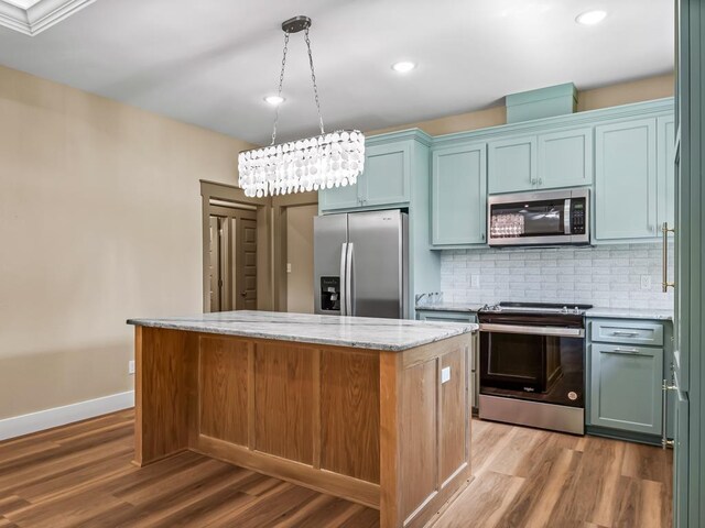 1673 Landing St, Carrabelle, FL 32322 - kitchen featuring appliances with stainless steel finishes, a kitchen island, light wood-type flooring, backsplash, and baseboards