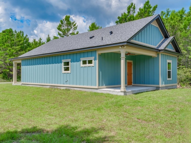 1673 Landing St, Carrabelle, FL 32322 - back of house with board and batten siding, a shingled roof, ceiling fan, a lawn, and a patio