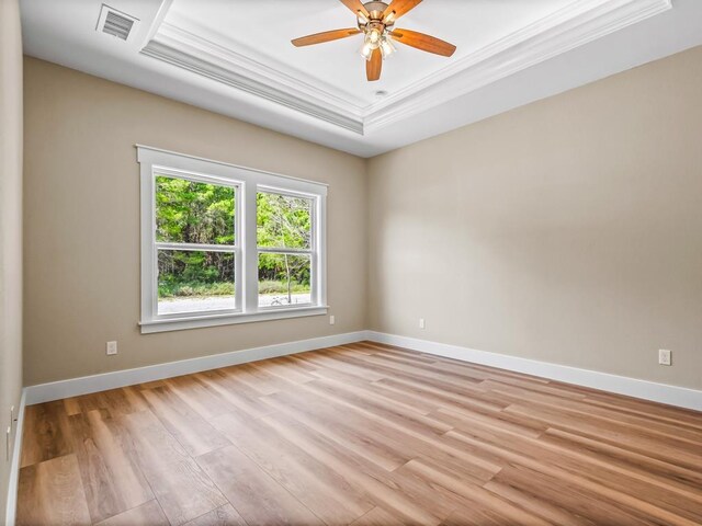 1673 Landing St, Carrabelle, FL 32322 - unfurnished room with ornamental molding, a tray ceiling, light wood-type flooring, baseboards, and a ceiling fan