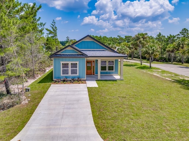 1673 Landing St, Carrabelle, FL 32322 - bungalow-style house with a front yard, covered porch, and view of scattered trees
