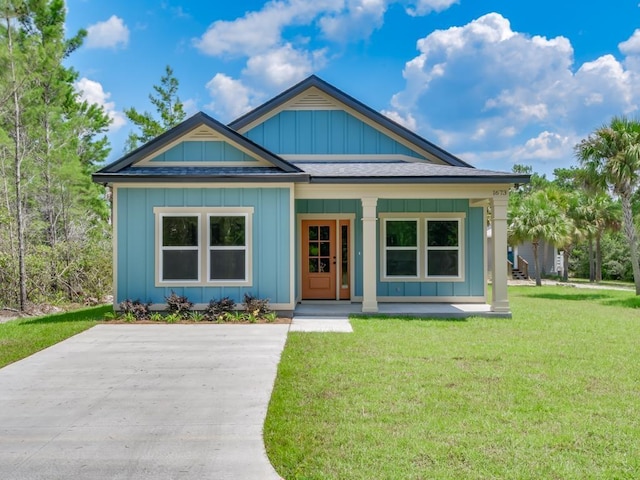 1673 Landing St, Carrabelle, FL 32322 - bungalow-style house featuring a porch, board and batten siding, a front yard, and roof with shingles