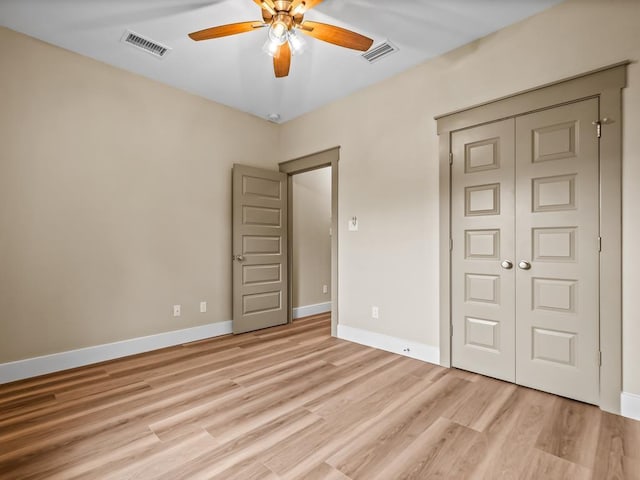 1673 Landing St, Carrabelle, FL 32322 - unfurnished bedroom featuring a closet, light wood finished floors, a ceiling fan, and baseboards