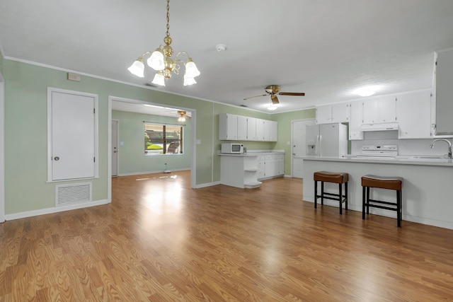 kitchen with sink, light hardwood / wood-style flooring, kitchen peninsula, white appliances, and white cabinets