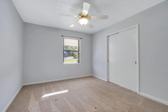 unfurnished bedroom with ceiling fan, carpet flooring, and a closet