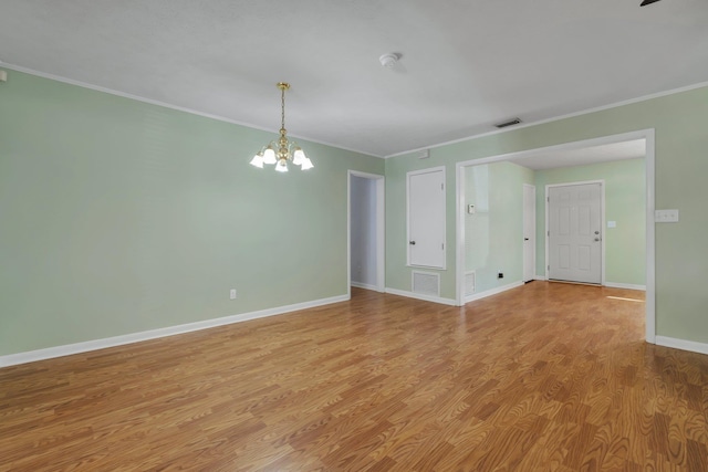 unfurnished room featuring crown molding, a notable chandelier, and light hardwood / wood-style floors