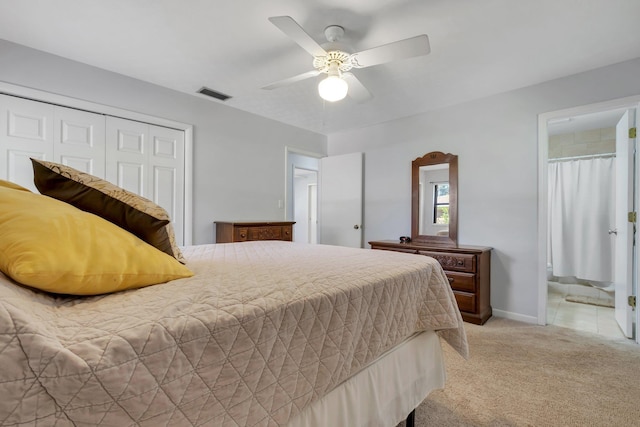 bedroom with ceiling fan, a closet, ensuite bath, and light carpet