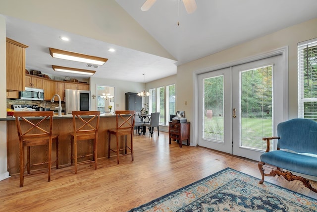 8171 Elysian Way, Tallahassee, FL 32311 - kitchen with stainless steel appliances, a chandelier, decorative backsplash, french doors, and light wood-style flooring