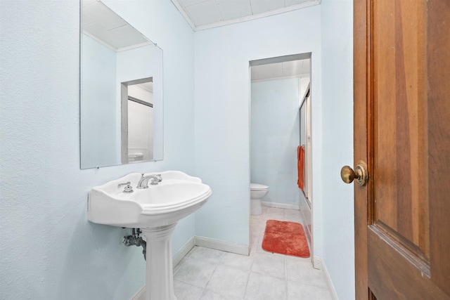 bathroom featuring ornamental molding, tile patterned floors, toilet, and an enclosed shower