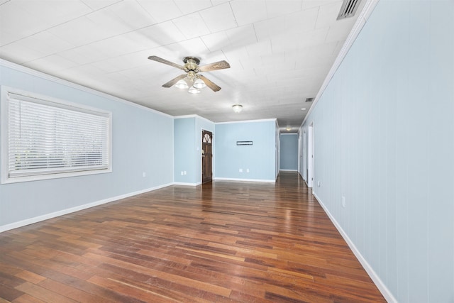 empty room featuring dark hardwood / wood-style flooring, crown molding, and ceiling fan