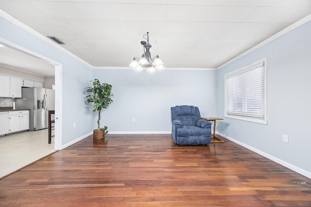 living area featuring dark hardwood / wood-style flooring, a notable chandelier, and crown molding