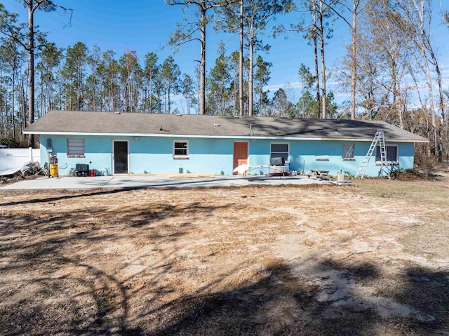 back of property featuring a patio and a lawn