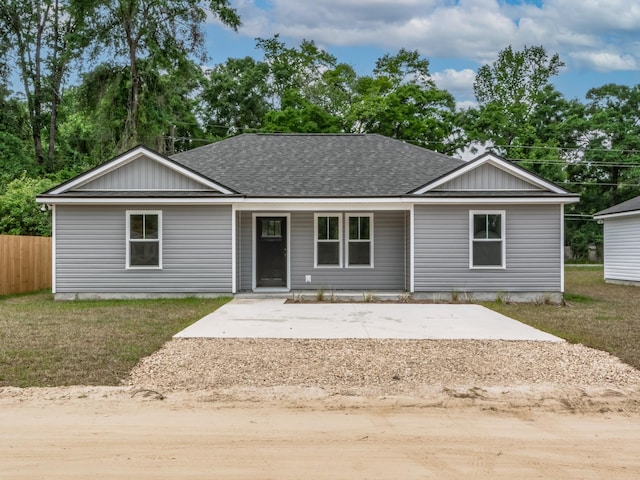ranch-style house with fence, a front lawn, and roof with shingles