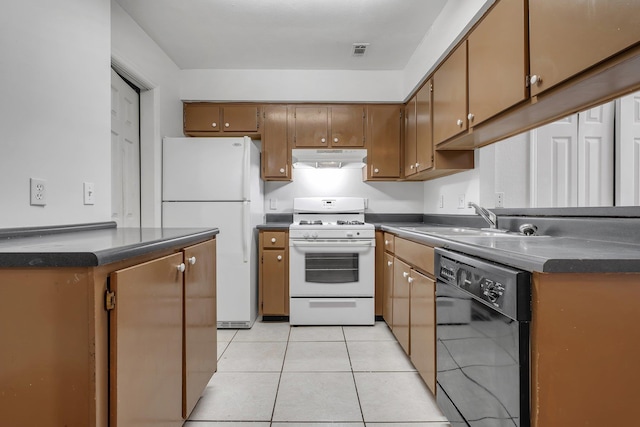 2467 Nugget Ln, Tallahassee, FL 32303 - kitchen with white appliances, under cabinet range hood, dark countertops, and light tile patterned flooring