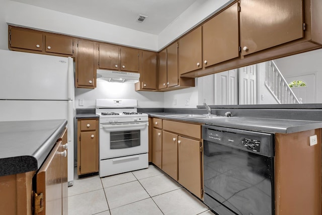 2467 Nugget Ln, Tallahassee, FL 32303 - kitchen with white appliances, under cabinet range hood, a sink, dark countertops, and light tile patterned floors