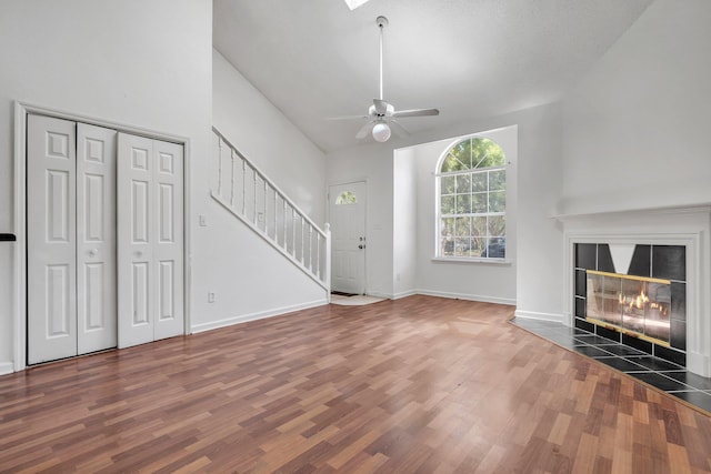 2467 Nugget Ln, Tallahassee, FL 32303 - unfurnished living room featuring wood finished floors, stairs, ceiling fan, a tile fireplace, and lofted ceiling