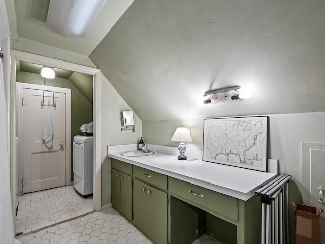 bathroom featuring vaulted ceiling, vanity, and washer / clothes dryer