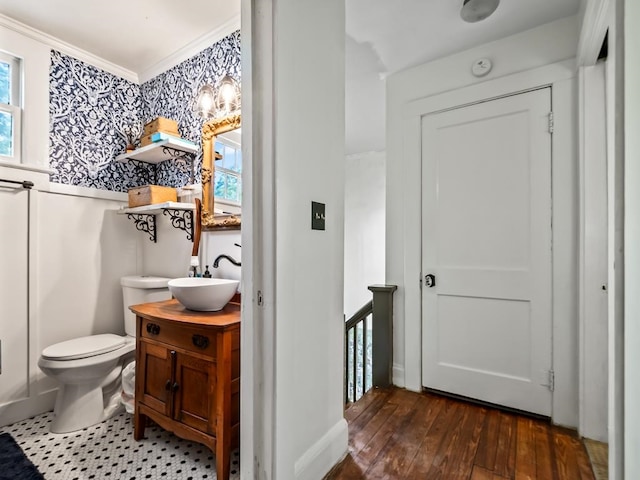 bathroom with toilet, hardwood / wood-style floors, vanity, and crown molding