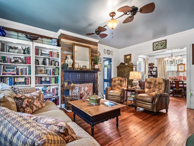 living room featuring ceiling fan with notable chandelier, dark hardwood / wood-style floors, and crown molding