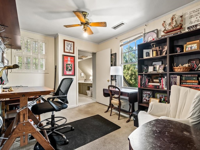 carpeted office featuring ceiling fan and crown molding