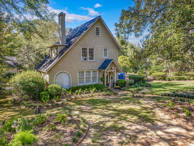 tudor home with a front lawn