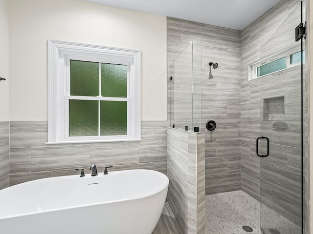 bathroom featuring independent shower and bath and tile walls