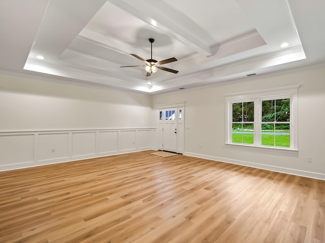 unfurnished room featuring light hardwood / wood-style floors, ceiling fan, crown molding, and a tray ceiling