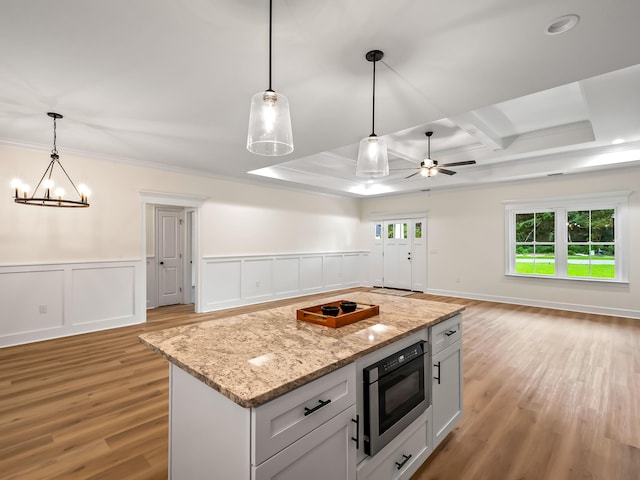 kitchen with white cabinets, decorative light fixtures, ceiling fan with notable chandelier, and light hardwood / wood-style flooring