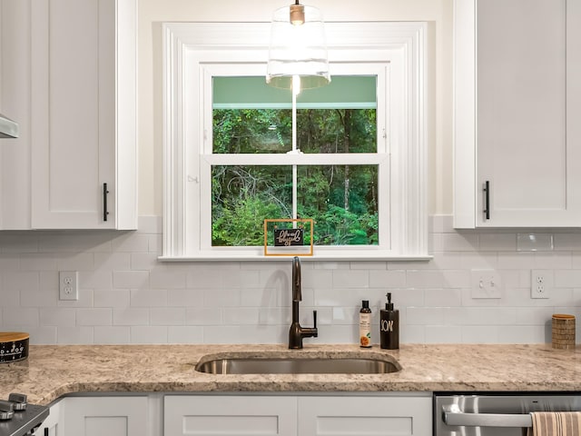 kitchen featuring tasteful backsplash, light stone countertops, sink, and white cabinets