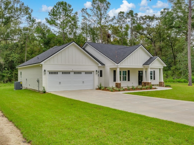 view of front of home with a garage, central AC, and a front lawn