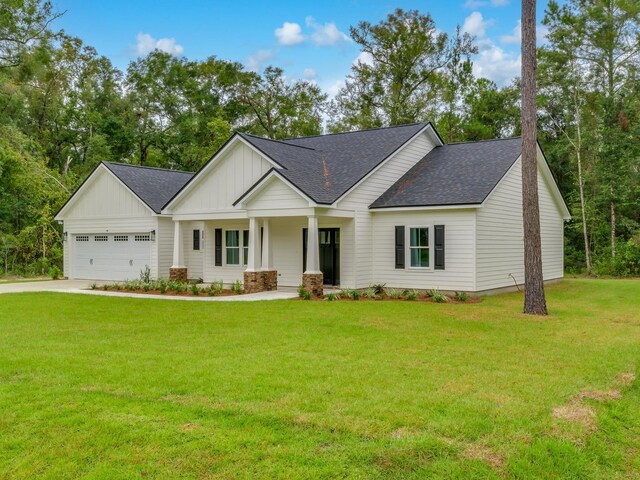 view of front of house featuring a garage, a porch, and a front yard