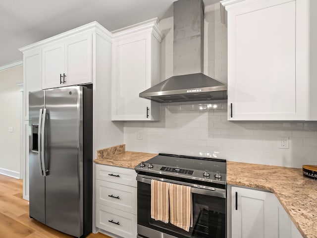 kitchen with white cabinets, wall chimney range hood, and appliances with stainless steel finishes