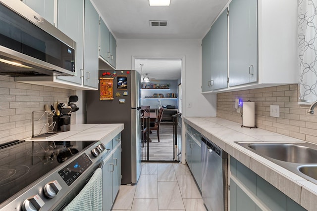 6812 Hill Gail Trl, Tallahassee, FL 32309 - kitchen with stainless steel appliances, a sink, decorative backsplash, and light countertops