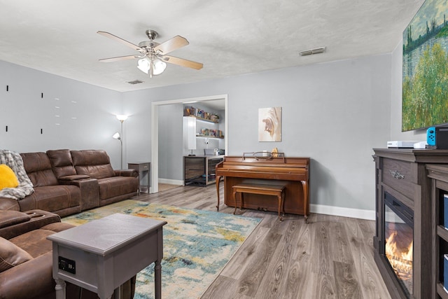 6812 Hill Gail Trl, Tallahassee, FL 32309 - living room featuring ceiling fan, baseboards, wood finished floors, and a glass covered fireplace