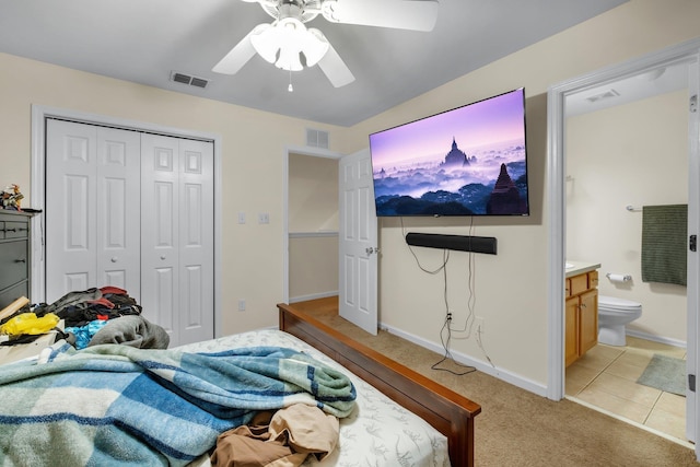 carpeted bedroom with ceiling fan, a closet, and ensuite bathroom