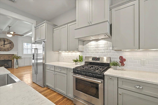 1261 Myrtle View Dr, Tallahassee, FL 32312 - kitchen featuring ceiling fan, light wood-style flooring, appliances with stainless steel finishes, exhaust hood, and gray cabinetry