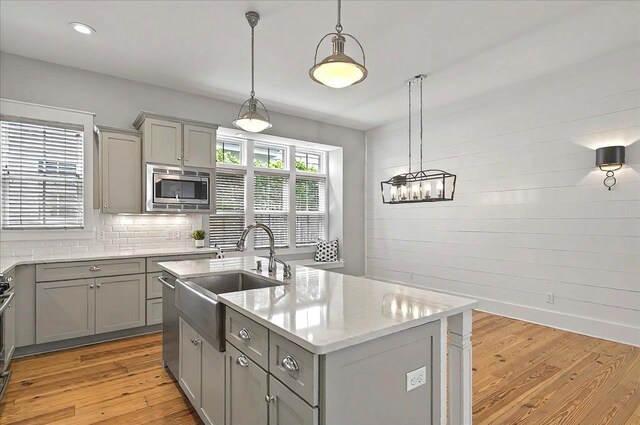 1261 Myrtle View Dr, Tallahassee, FL 32312 - kitchen featuring appliances with stainless steel finishes, a sink, an island with sink, gray cabinets, and light wood-type flooring
