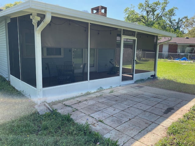 320 Lancaster Dr, Tallahassee, FL 32304 - back of property featuring a sunroom, fence, a yard, and a chimney