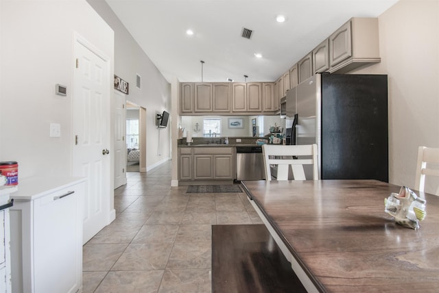 kitchen with light tile patterned flooring, appliances with stainless steel finishes, light brown cabinetry, lofted ceiling, and sink