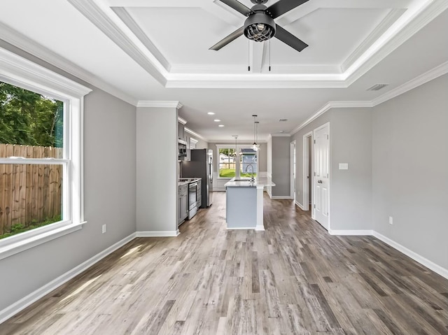 unfurnished living room with ceiling fan, ornamental molding, wood-type flooring, and sink